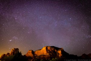 The night sky in Sedona, Az. with the red rock formations in the foreground.